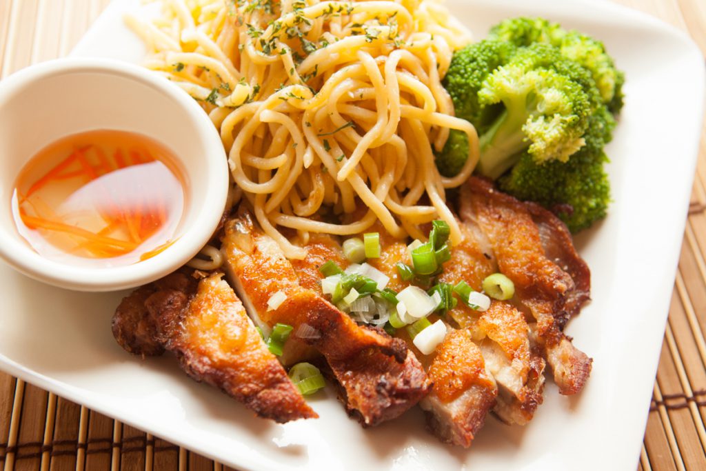 a plate of food with noodles, broccoli and sauce.