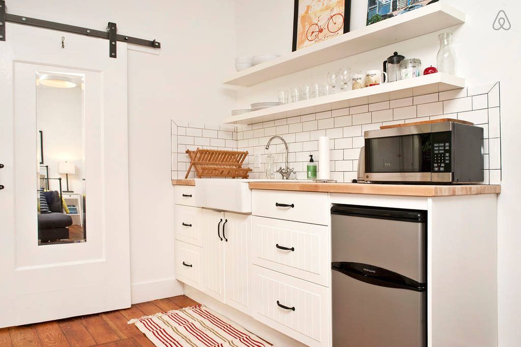 a kitchen with white cabinets and a black microwave.