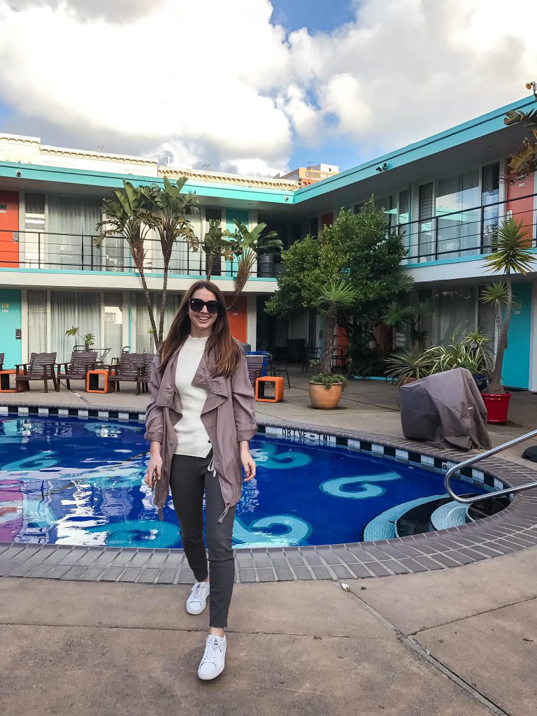 a woman standing in front of a swimming pool.