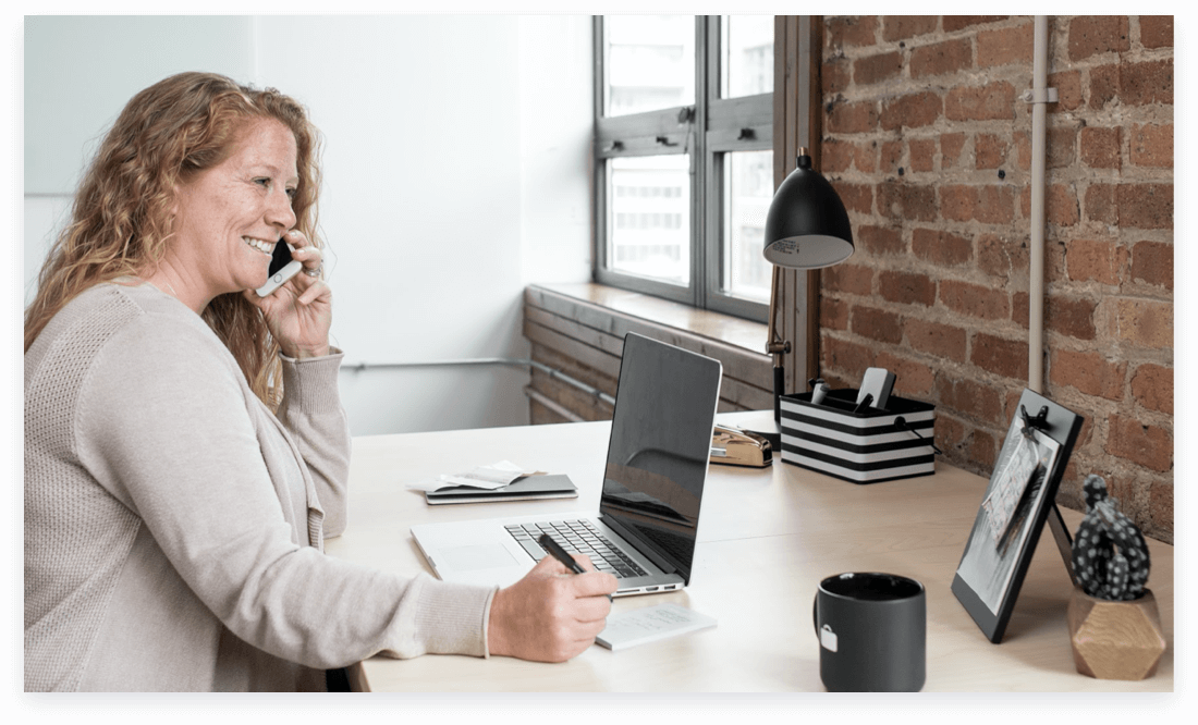 Woman answering support call with laptop