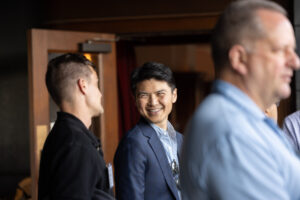 A group of men and women standing in a room.