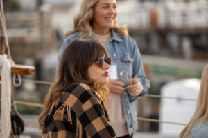 Three women on a boat talking to each other.