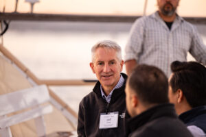 A group of people sitting on a boat talking to each other.
