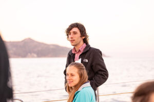 A group of people standing on the deck of a boat.