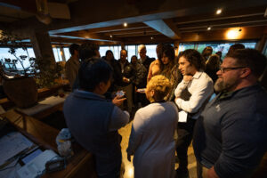 A group of people standing around a bar.