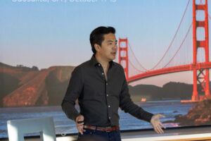 A man is standing in front of a golden gate bridge.