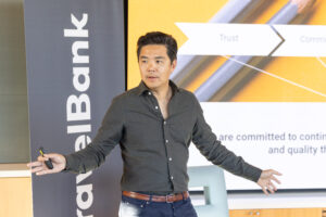 A man standing in front of a screen giving a presentation.