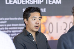 A man talking to a group of people at an event.