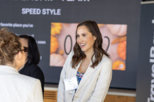 A woman is talking to another woman at an event.