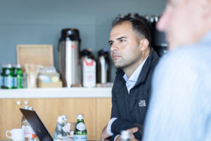 A man sitting at a table with a laptop.