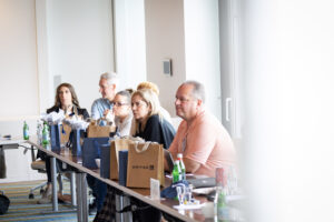 A group of people sitting at a table in a conference room.