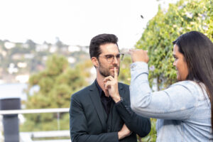 A man in glasses is talking to a woman.