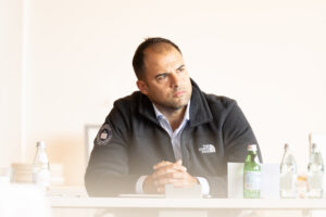 A man sitting at a table with a bottle of water.