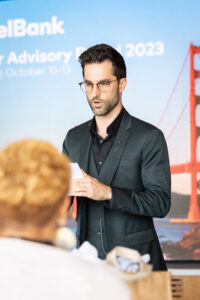 A man in a suit standing in front of a group of people.