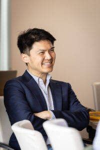 A man in a suit sitting in a conference room.