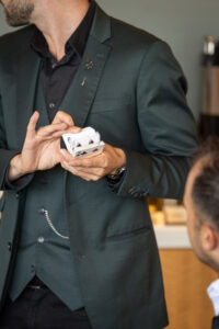 A man in a suit is holding a card in his hand.