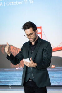 A man giving a thumbs up in front of the golden gate bridge.