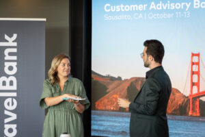 A man and woman standing in front of a screen.