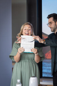 A man and a woman holding up a piece of paper.