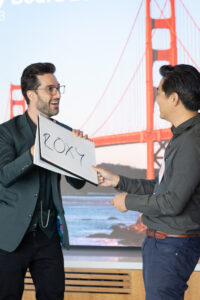 A man holding a sign in front of a golden gate bridge.