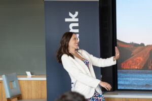 A woman standing in front of a large screen.