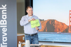 A man holding up a sign in front of a screen.