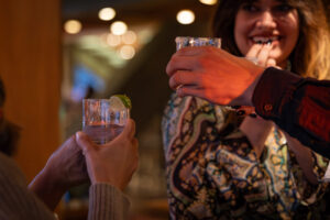 A group of people toasting drinks in a bar.