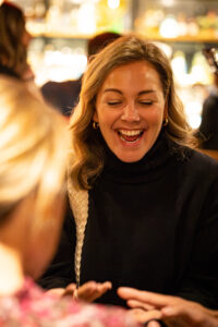 Two women laughing at a table in a restaurant.
