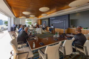 A group of people sitting at tables in a conference room.