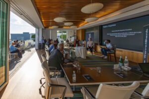 A group of people sitting at a table in a conference room.