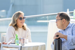 Two people sitting at a table talking to each other.