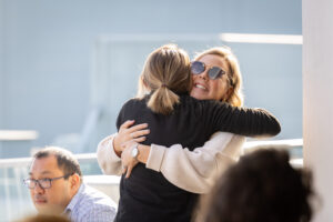 A woman is hugging another woman at an event.