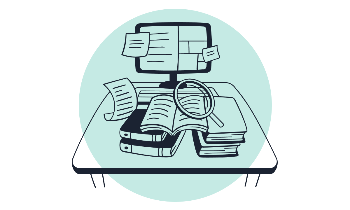 A desk with open books, stacked books, loose papers, a magnifying glass, and a computer monitor displaying sticky notes and documents.